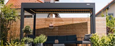 Espacio exterior moderno con pérgola, sofá cómodo y decoración elegante, ideal para relajarse y disfrutar al aire libre.

