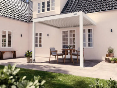 Foto de una pérgola 3x3 blanca adosada a muro en un patio en un día de sol