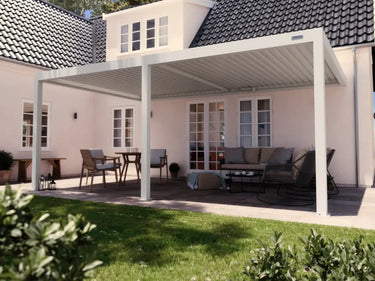 Foto de una pérgola 4x6 blanca aadosada a muro en un patio en un día de sol